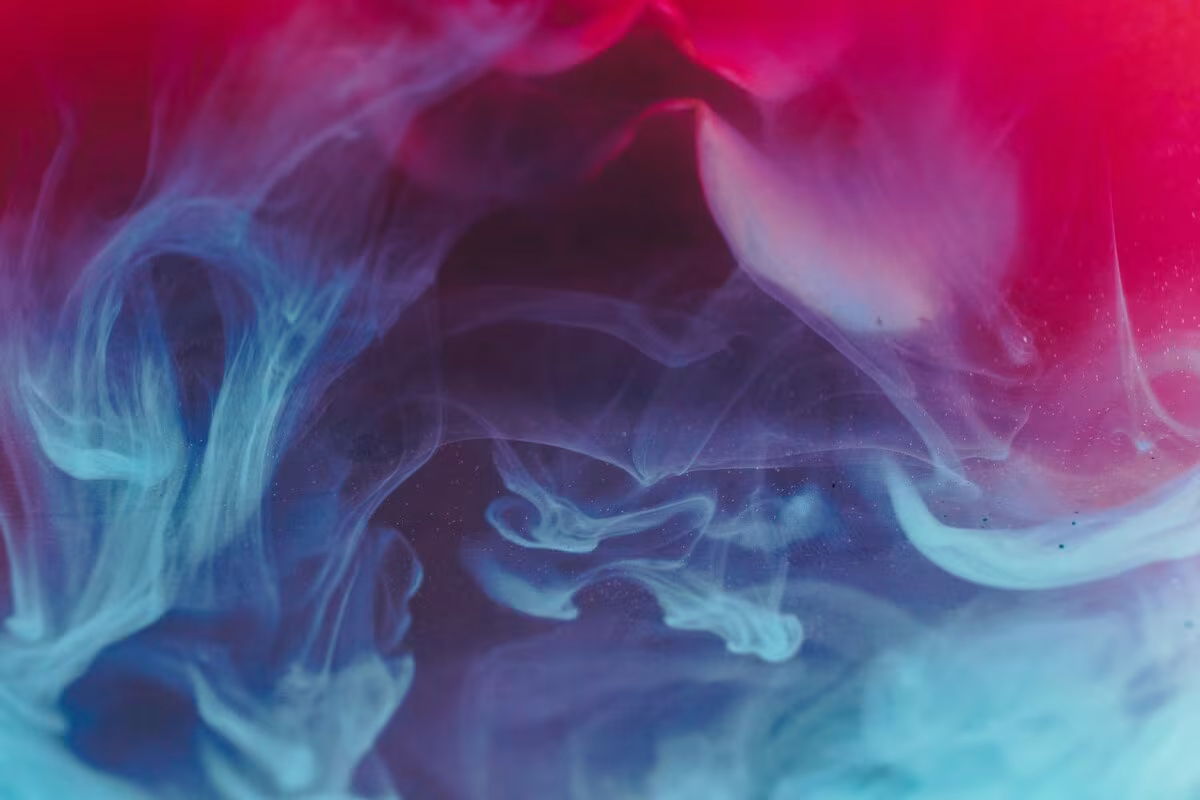 Nubes de humo azul y rosa sobre un fondo morado