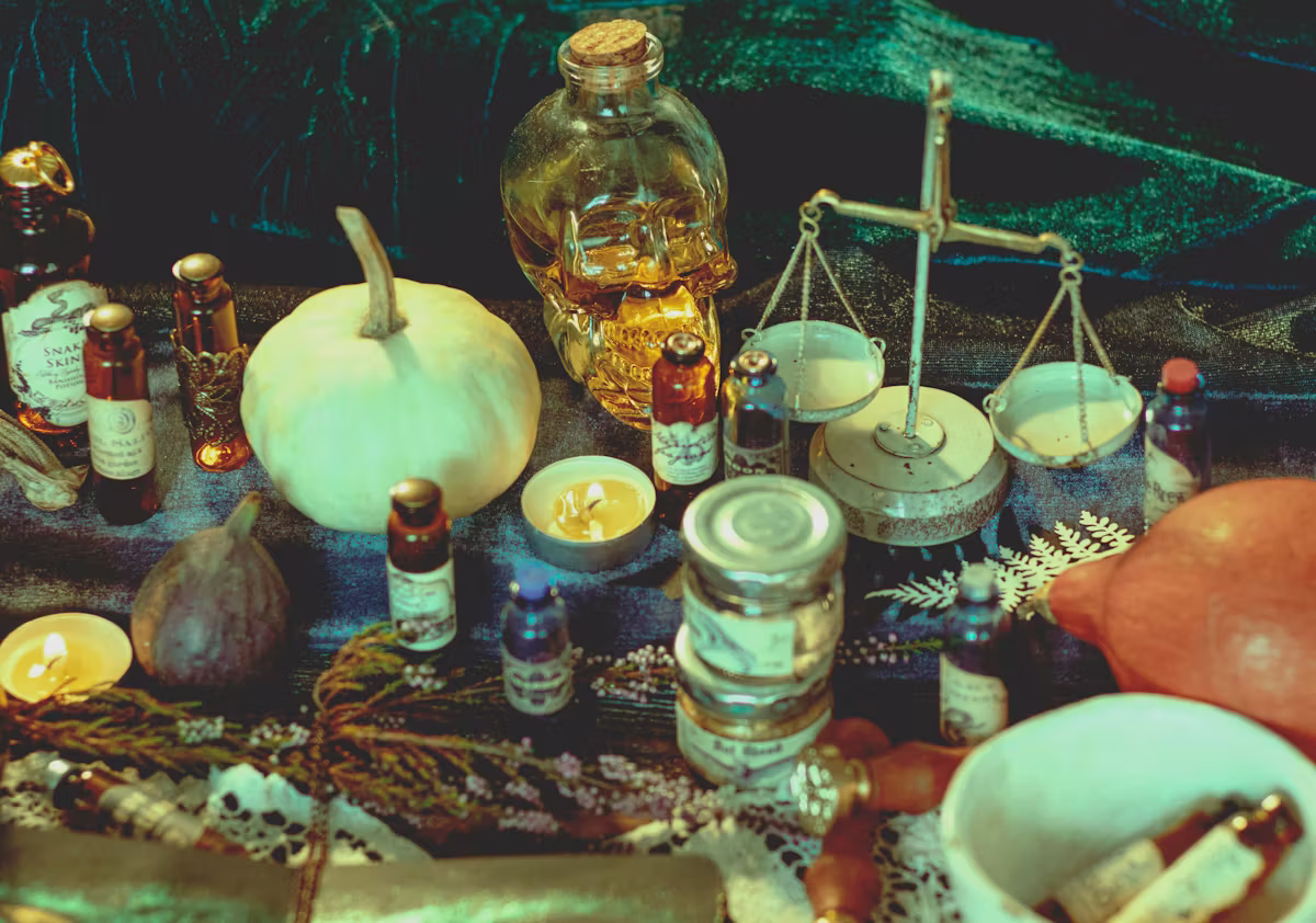Frascos de vidrio, balanza, calabaza y velas sobre una mesa