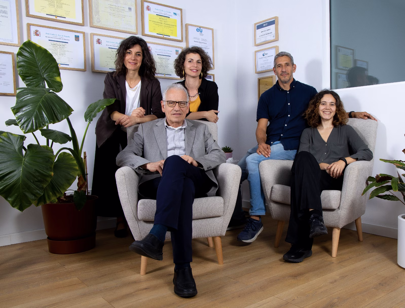 Profesionales de Clínica Synaptica, centro de terapia psicodélica en Barcelona, reunidos junto a una gran planta