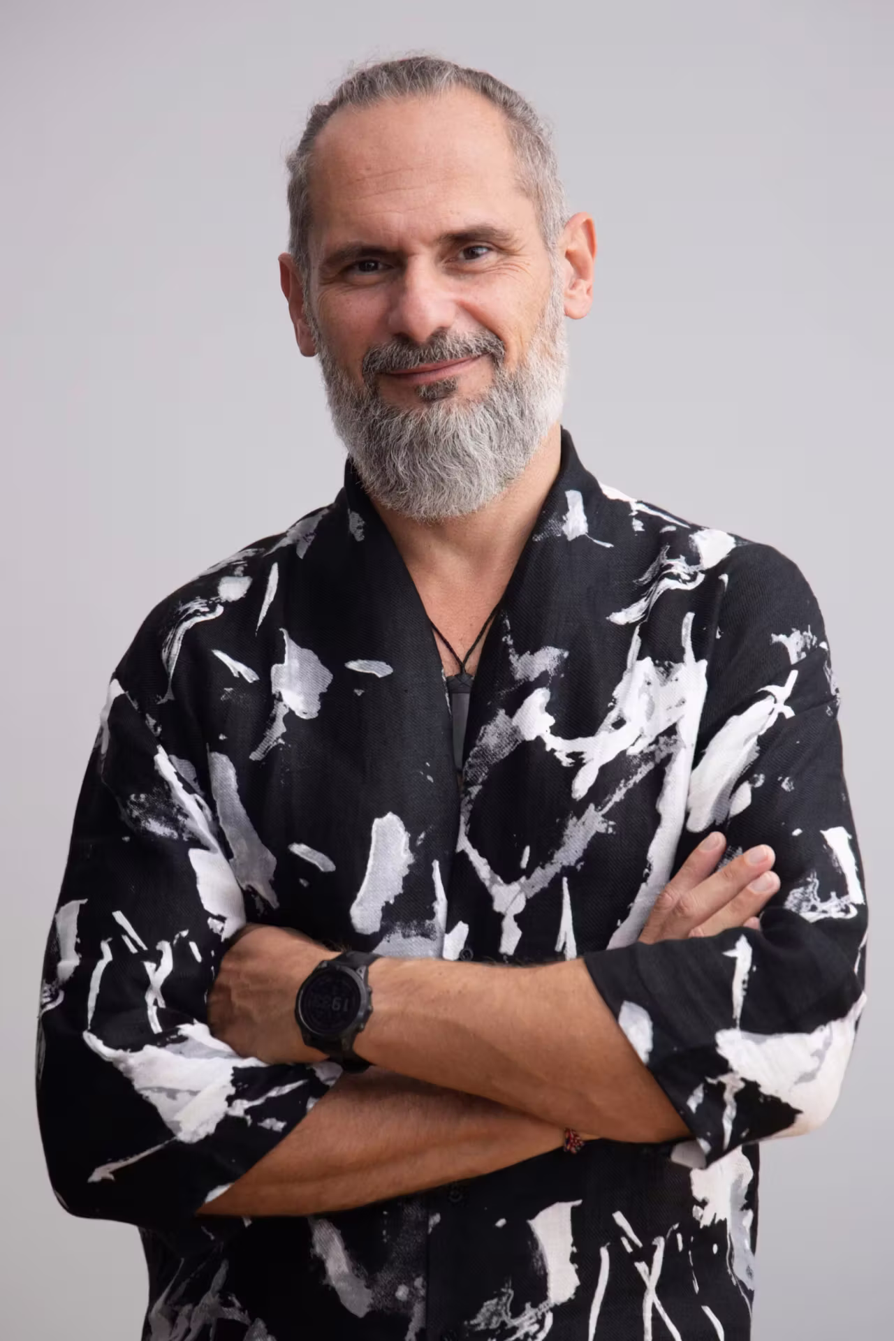 Jacek Szczęsny, trauma-informed physician, with a grey beard and patterned shirt, arms crossed