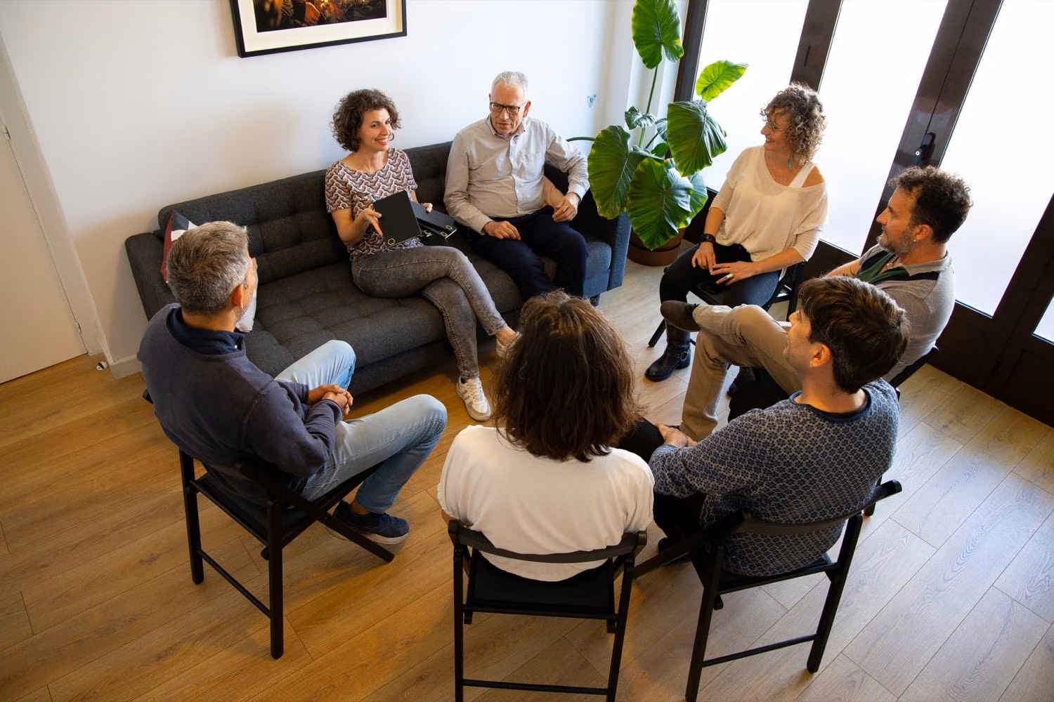 Sesión de terapia de grupo con siete personas sentadas en círculo